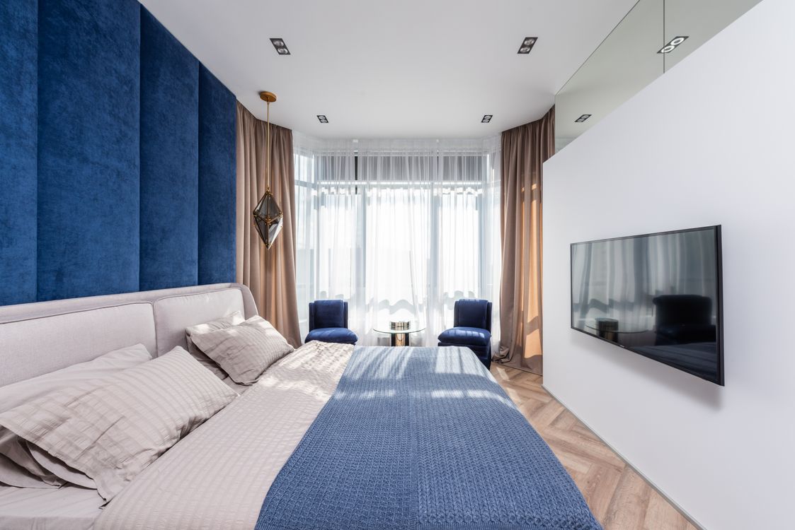 Deep blue velvet accent wall in an elegant bedroom