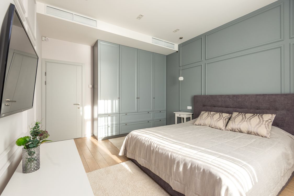 Sage green paneled accent wall in a bedroom